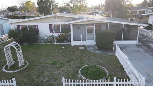 view of front facade featuring a sunroom, a fenced backyard, and a front yard