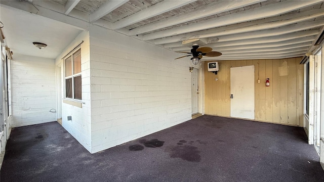 entrance to property featuring a ceiling fan and concrete block siding