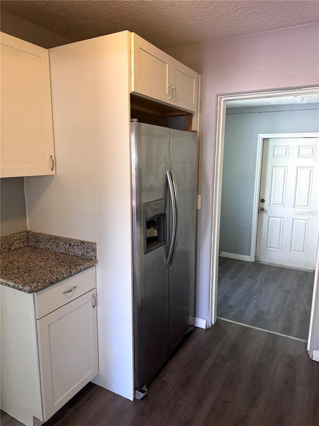 kitchen featuring a textured ceiling, stone countertops, dark wood-style flooring, white cabinetry, and stainless steel fridge with ice dispenser