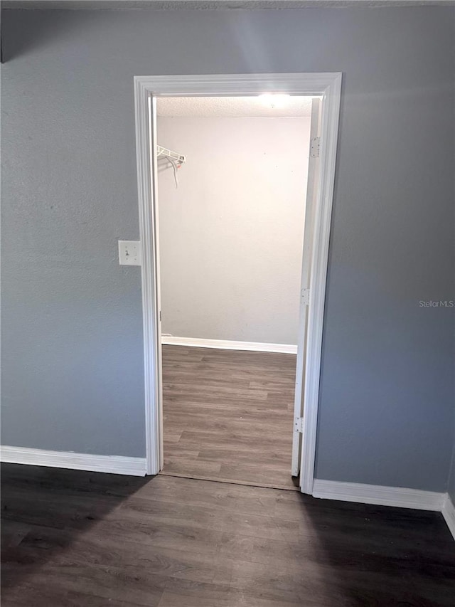 unfurnished room with baseboards and wood finished floors