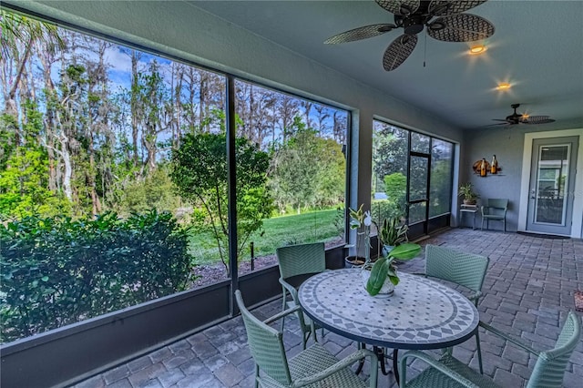 unfurnished sunroom with a ceiling fan