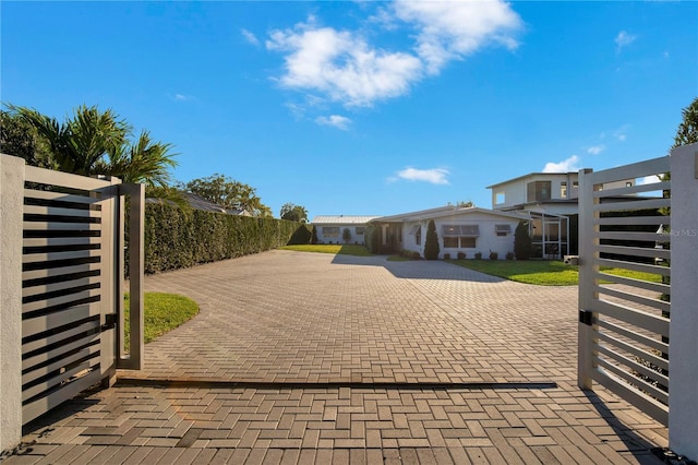 view of gate with fence and a patio