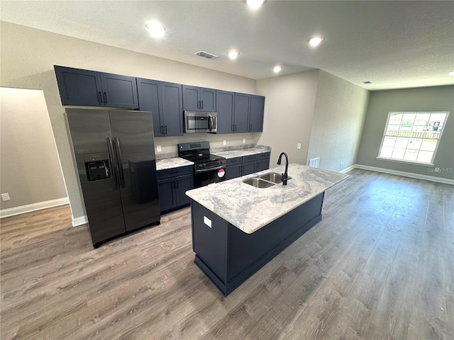 kitchen with visible vents, black fridge, electric stove, a sink, and stainless steel microwave