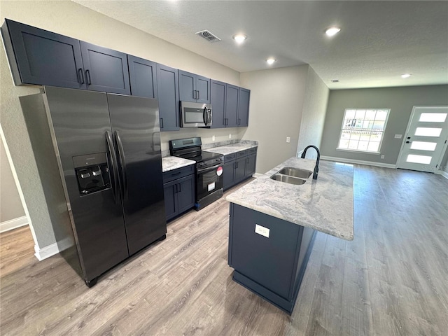 kitchen featuring visible vents, light wood-style flooring, appliances with stainless steel finishes, and a sink