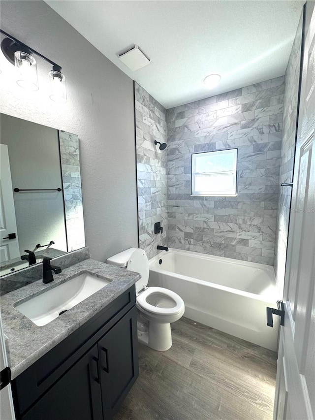 full bathroom featuring visible vents, toilet, wood finished floors,  shower combination, and vanity