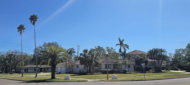 view of front of house featuring a garage, driveway, a front lawn, and a residential view