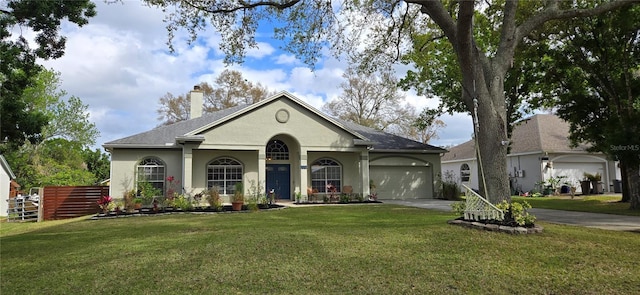 view of front facade featuring driveway, a chimney, a front lawn, and stucco siding