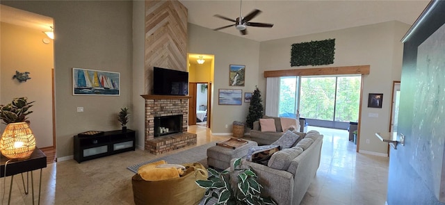 living area with high vaulted ceiling, a brick fireplace, baseboards, and a ceiling fan