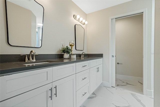 full bath featuring marble finish floor, a sink, baseboards, and double vanity