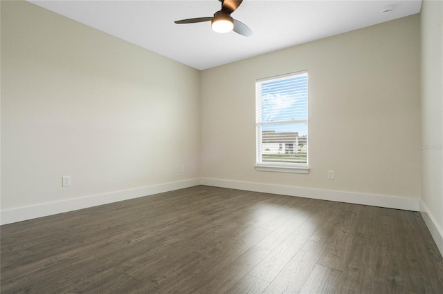 empty room featuring dark wood-style floors, baseboards, and a ceiling fan