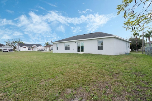 back of house featuring a yard and stucco siding