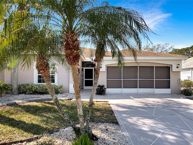 view of front of home featuring driveway, an attached garage, and stucco siding