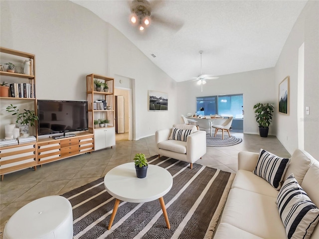 tiled living room with visible vents, high vaulted ceiling, and a ceiling fan