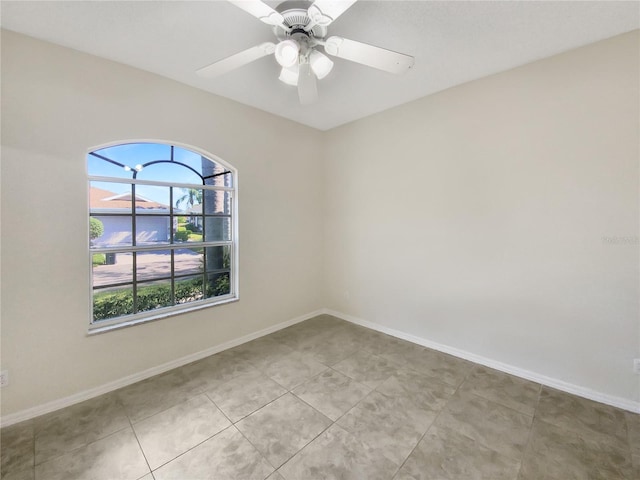 unfurnished room with baseboards, a ceiling fan, and light tile patterned flooring