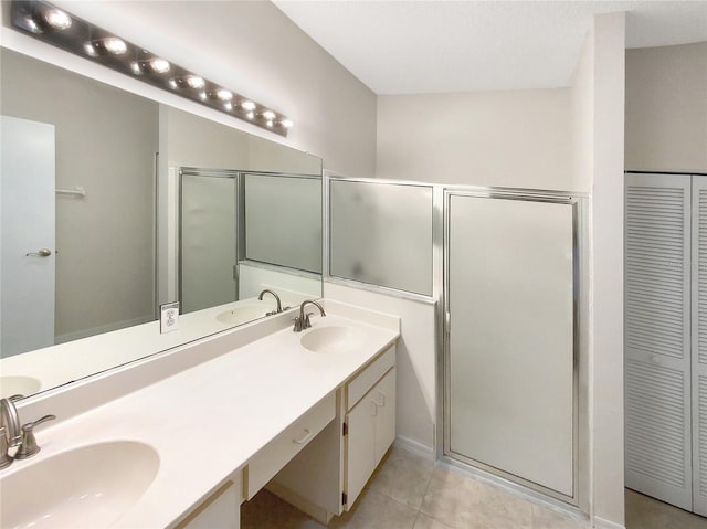 full bath with tile patterned flooring, a closet, a sink, and double vanity