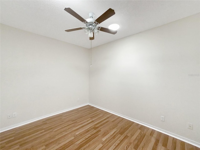 unfurnished room with a ceiling fan, baseboards, and wood finished floors