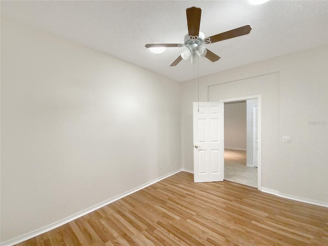 unfurnished room featuring light wood-style floors, ceiling fan, and baseboards