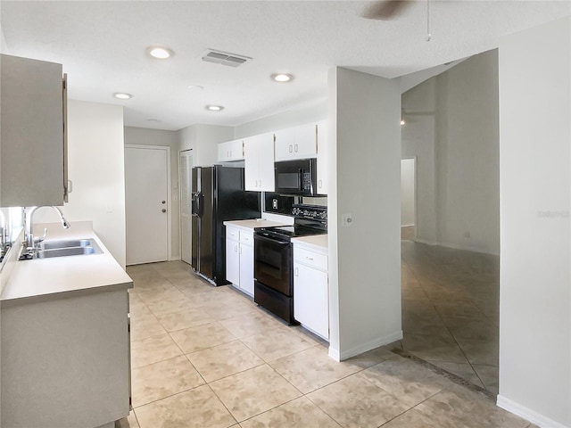 kitchen with white cabinets, light countertops, a sink, and black appliances