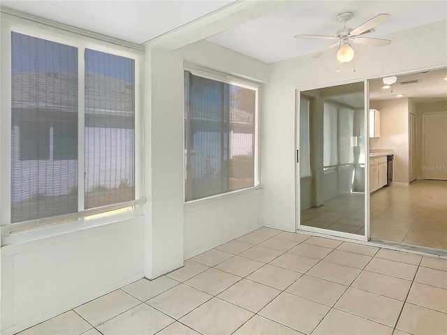 empty room with light tile patterned floors and ceiling fan