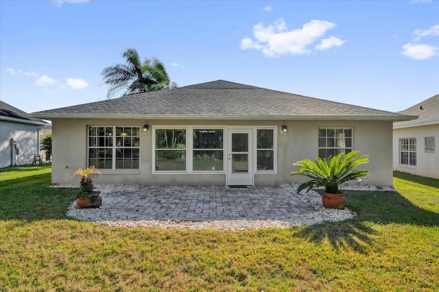 back of property with a patio, stucco siding, a lawn, and a shingled roof