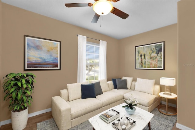 living area with ceiling fan, baseboards, and wood finished floors