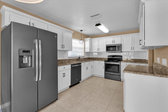 kitchen featuring visible vents, backsplash, appliances with stainless steel finishes, white cabinets, and a sink