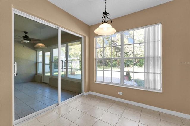 doorway featuring a wealth of natural light, baseboards, and light tile patterned floors