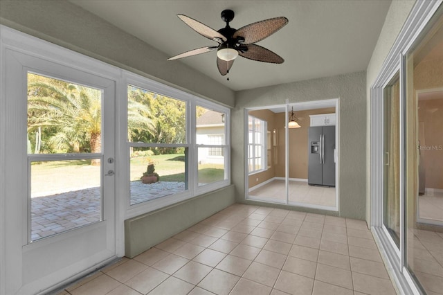 unfurnished sunroom with a ceiling fan