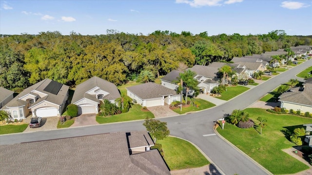 drone / aerial view featuring a residential view and a forest view