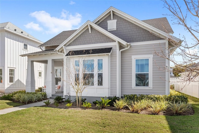 view of front of house with a front lawn and roof with shingles