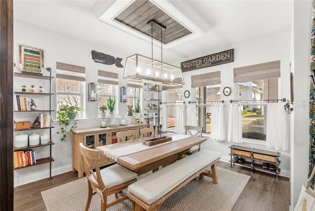 dining space featuring a chandelier, wood finished floors, and baseboards