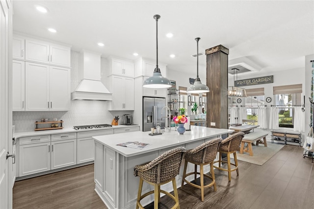 kitchen featuring custom range hood, a breakfast bar, dark wood-style flooring, stainless steel appliances, and light countertops