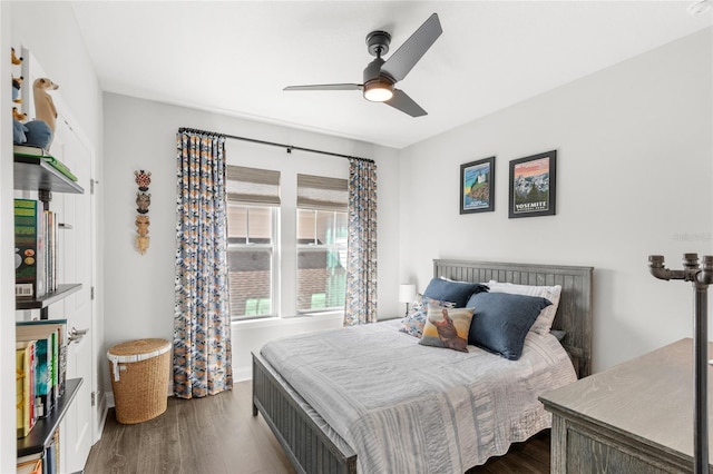 bedroom with dark wood-style floors, ceiling fan, and baseboards