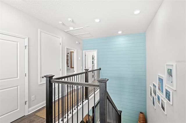 corridor featuring recessed lighting, wood finished floors, an upstairs landing, baseboards, and attic access