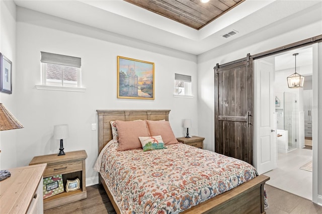 bedroom featuring a barn door, wood finished floors, visible vents, wood ceiling, and a raised ceiling