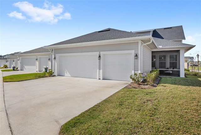 view of front of property featuring a garage, a sunroom, concrete driveway, roof with shingles, and a front yard