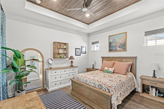 bedroom featuring a ceiling fan, wood ceiling, a tray ceiling, and wood finished floors