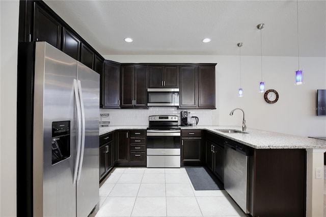 kitchen with light tile patterned floors, stainless steel appliances, decorative backsplash, a sink, and a peninsula