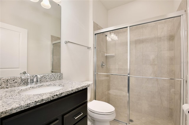 full bath featuring toilet, a shower stall, and vanity