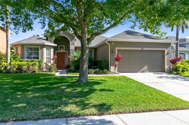 single story home with a garage, concrete driveway, a front yard, and stucco siding