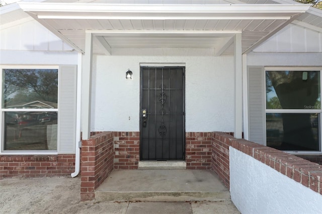 view of exterior entry featuring brick siding