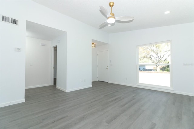 spare room with a ceiling fan, baseboards, and wood finished floors