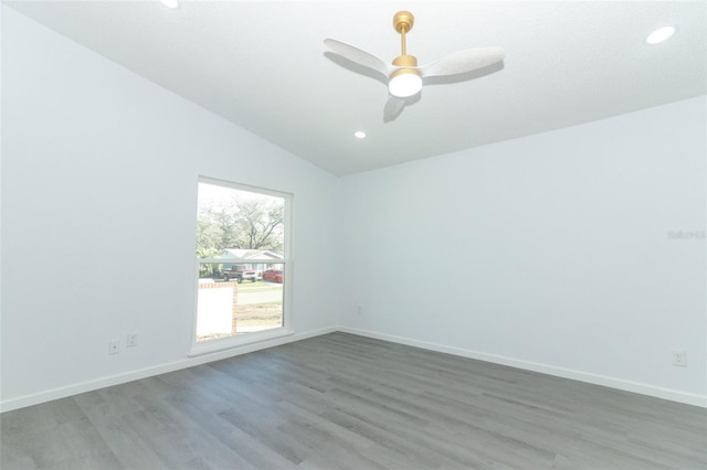 unfurnished room with lofted ceiling, baseboards, and wood finished floors