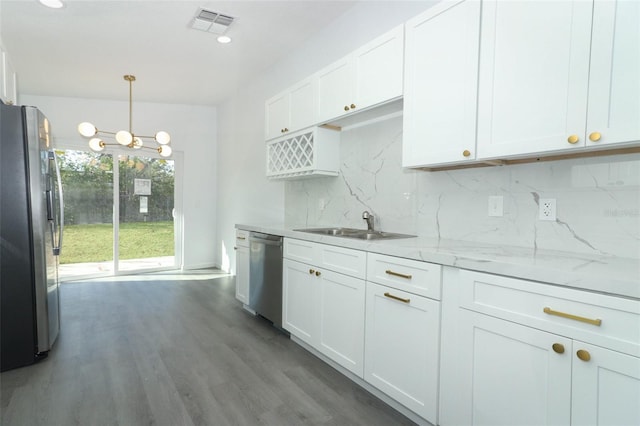 kitchen with stainless steel appliances, a sink, white cabinets, and decorative backsplash