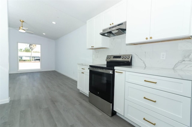 kitchen with lofted ceiling, under cabinet range hood, electric range, white cabinetry, and backsplash