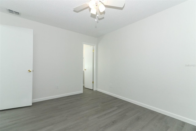 empty room featuring baseboards, visible vents, ceiling fan, wood finished floors, and a textured ceiling