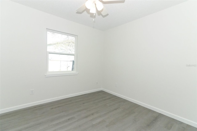 spare room with a ceiling fan, baseboards, and wood finished floors