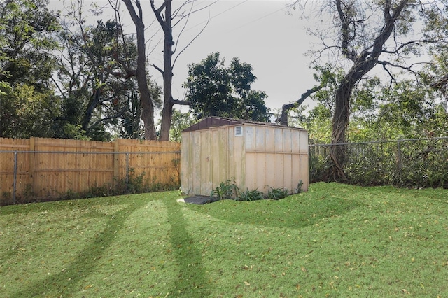 view of yard with a shed, a fenced backyard, and an outdoor structure