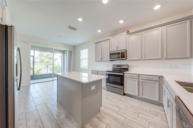 kitchen featuring light countertops, appliances with stainless steel finishes, a kitchen island, and visible vents