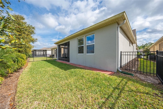 back of property featuring a yard, fence, and stucco siding